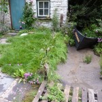 The dry creek with its boat in the Welsh garden
