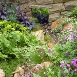 A rill weaves through the wall and between naturalistic planting as it would on the moors in the Yorkshire garden