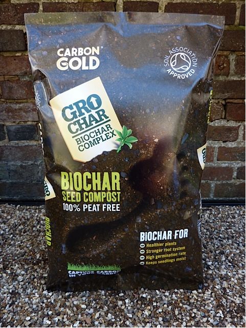 grochar-compost bag of compost against a brick wall
