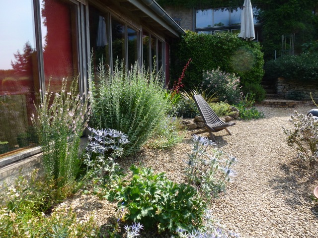 a modern gravel garden by house with full length glazing