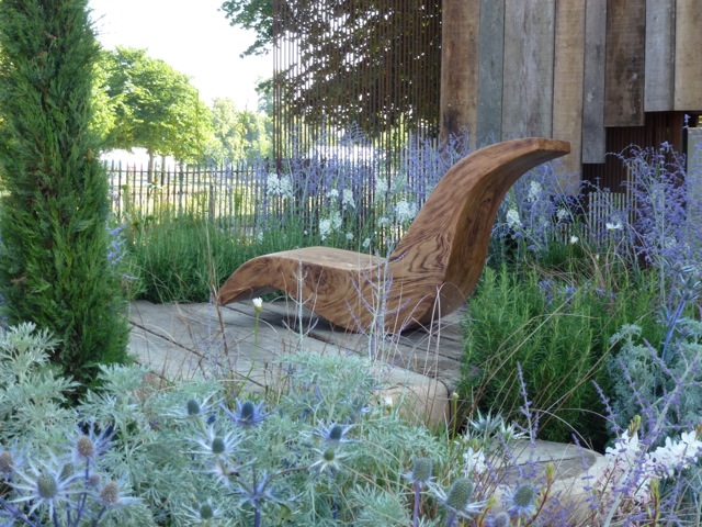 a modern chair sits in the centre of the garden