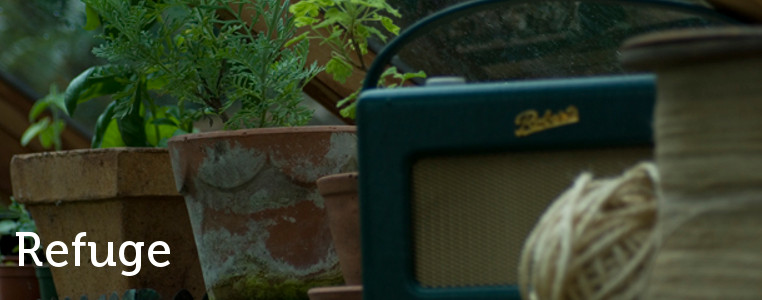 a roberts radio amongst potted plantes in a greenhouse
