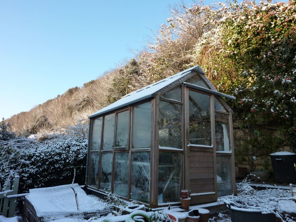 snow capped greenhouse in the winter