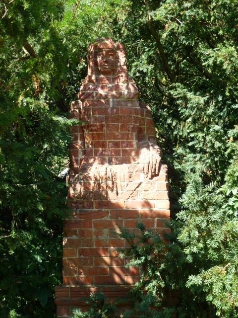 statue of person carved from red bricks