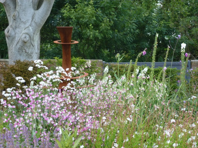 grasses in the foreground and a corten steel feature in the background
